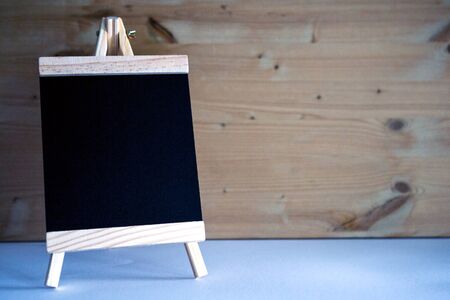 small chalkboard on table with wooden backgroundの写真素材