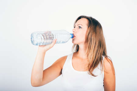 blond woman drinking water from a bottleの写真素材