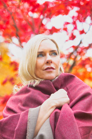 portrait of blond woman in her 40s outdoors in autumnの写真素材
