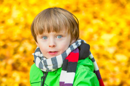 portrait of a young boy outdoors in oark in autumnの写真素材