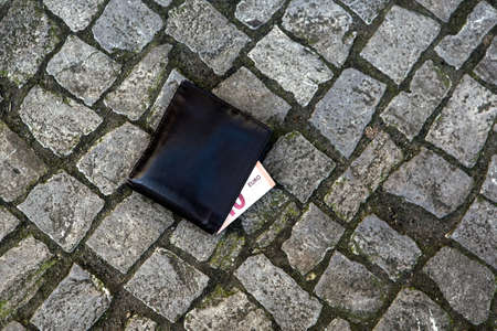 close-up of leather wallet lying on streetの写真素材