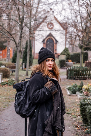 young sad brunette woman walking alone in cemeteryの写真素材