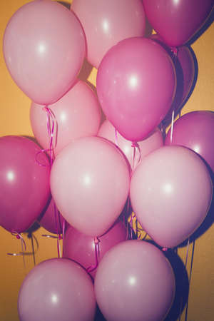 bunch of pink balloons on yellow backgroundの写真素材