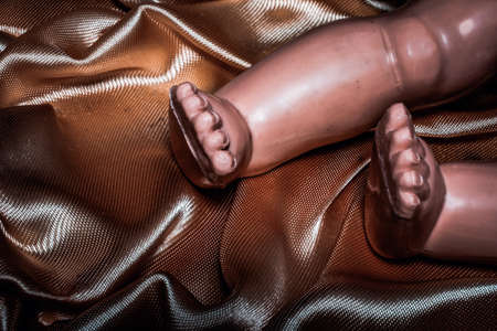 close-up of old doll legs on golden fabricの写真素材