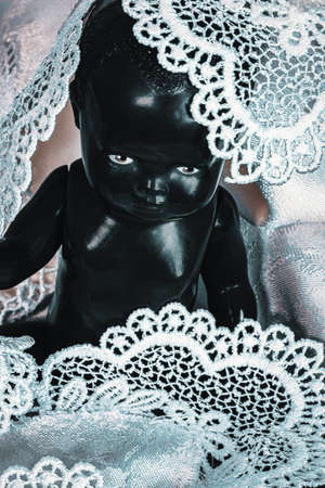 close-up of black doll covered in white laceの写真素材