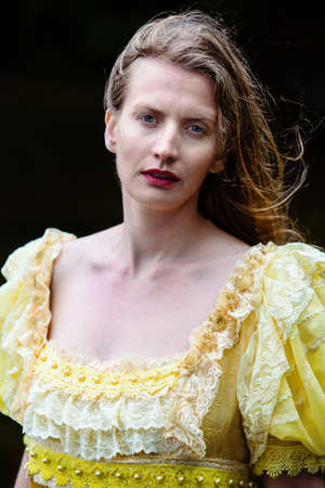 portrait of blond woman in a historic yellow dressの写真素材