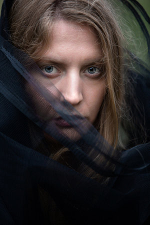 portrait of a sad young woman wearing black veil