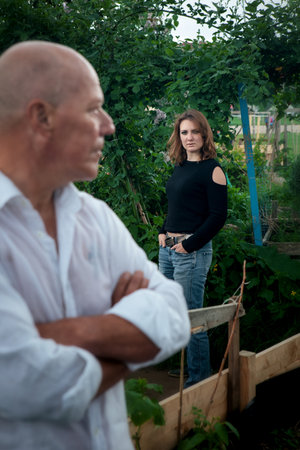 portrait of man in wet shirt and woman standing outdoorsの写真素材