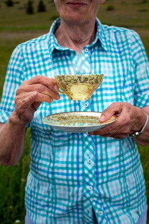 close-up of an older woman holding a tea cupの写真素材
