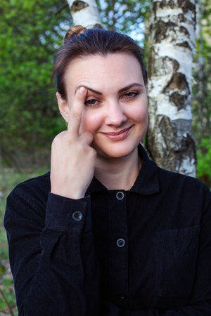Portrait of young woman showing middle fingerの写真素材