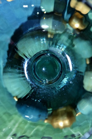 gold color pine cone seen through wine glassの写真素材