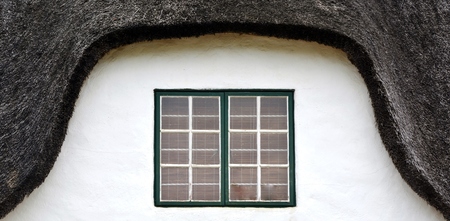 Close up of a window on a thatch roof houseの写真素材