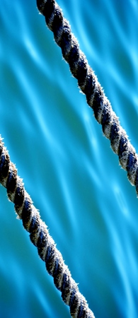 Close up of ship ropes hanging over waterの写真素材