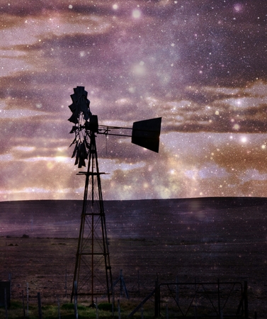 Landscape with water pump windmill at sunriseの写真素材