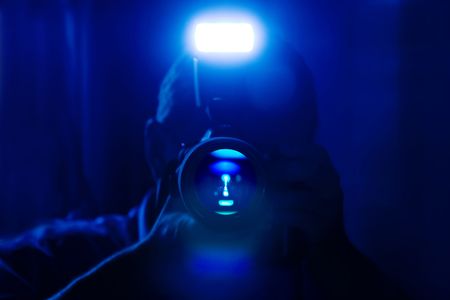 Photographer shooting with flash in dark blueの写真素材