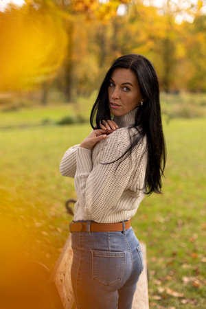 Portrait of a beautiful young brunette woman in the autumn parkの写真素材