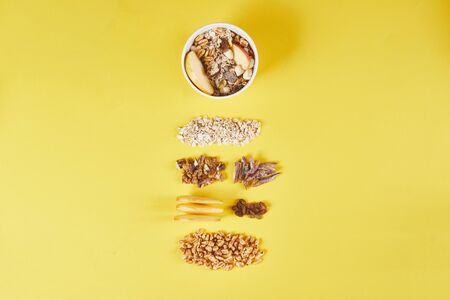 Bowl with tasty granola and ingredients on a color backgroundの写真素材