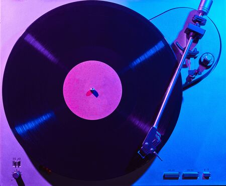 Retro wave, 80s. Record player with a neon light. Vinyl analog turntable. Synthwave and vaporwave concept.の写真素材