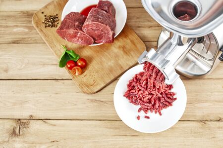Fresh forcemeat, cutting board with Meat grinder on kitchen table. Top view. Copy space.