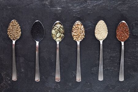 Various Seeds Assortment on dark background. Set of seed: sesame, sunflower, pumpkin, flax, hemp,...