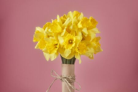 Bouquet of yellow spring flowers. Bunch narcissus packed craft paper with a greeting card.Spring card for Mother's Dayの写真素材