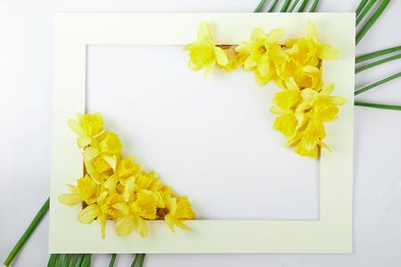 Paper frame wreath pattern with yellow narcissus. Floral composition on table for greeting card, mothers, easter day.top viewの写真素材