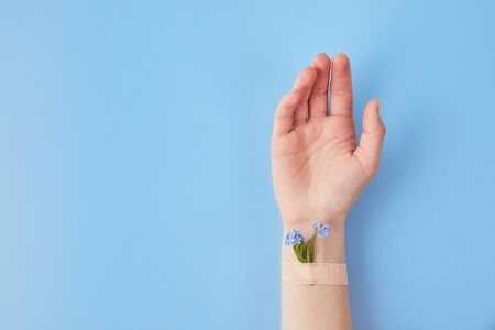 Hand cosmetics with flower and adhesive plasters. Cosmetics for hands anti wrinkle, day spa, beauty salon, manicure conceptの写真素材