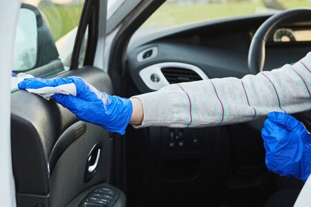Female hand spraying sanitizer and antiseptic wet wipes for disinfecting car. Cleanliness and health...