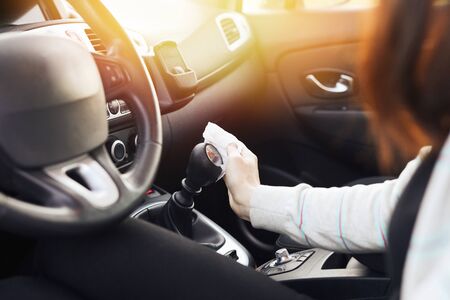 Female hand spraying sanitizer and antiseptic wet wipes for disinfecting car. Cleanliness and...