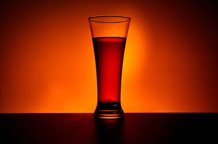 Tall glass of cold tea on warm yellow background. Fresh summer beverage.の写真素材