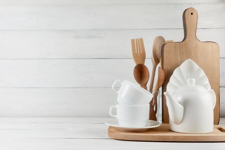 Blank space for kitchen wide banner concept. Kitchen background for mockup with spoon, teapot, cups, rolling pin, bowls on wooden table, white background.の写真素材