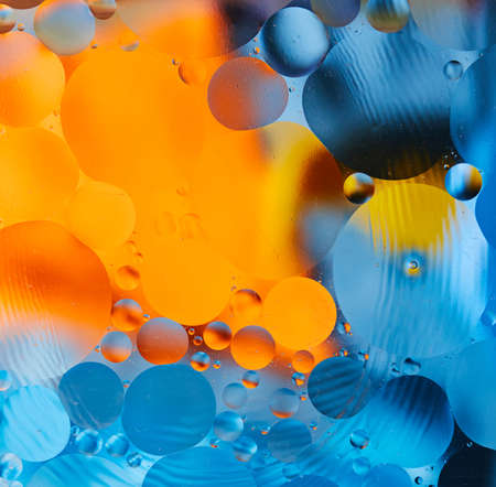 Abstract background with vibrant colors. Experiment with oil drops on water. Close up artful and colorful bubbles.の写真素材
