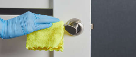 Female hands disinfect, clean and wash of door handles. Prevention of coronavirus infection during...