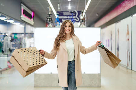 Happy woman with paper shopping bags. Consumerism and lifestyle concept. Woman in shopping.