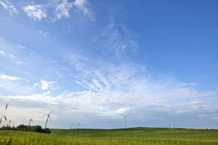 Wind turbine on the green grass over the blue clouded sky. Protection of nature. Wind turbine -...