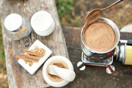 Hot drink on nature. Process of cooking coffee with spices in nature. Background - camping and...