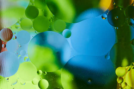 Abstract background with vibrant colors. Experiment with oil drops on water. Close up artful and colorful bubbles.の写真素材