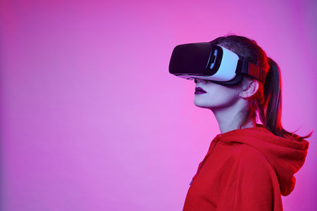Woman's playing in VR-glasses in neon light on blue background. Girl in VR goggles choosing options...