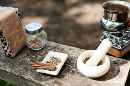 Hot drink on nature. Process of cooking coffee with spices in nature. Background - camping and forest.の写真素材