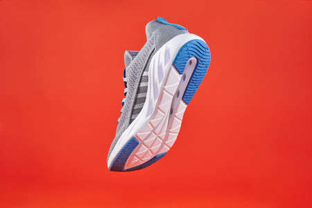 Stability and cushion running shoes. New unbranded running sneaker or trainer on orange background....