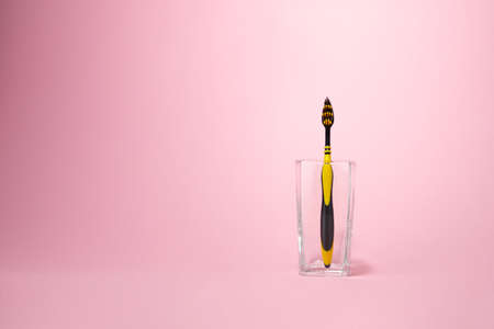 Yellow toothbrush with a small glass for brushing your teeth.の写真素材