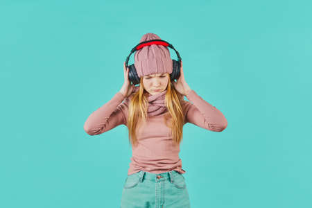 Beautiful young woman listening to music using headphones. sad expression.の写真素材
