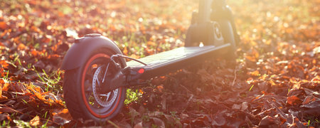 Autumn shot of sunset with electric scooter or e-scooter. Eco friendly city transport for transportation.の写真素材