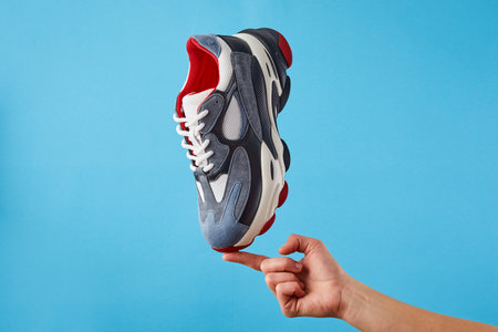 Casual sports shoes for running and walking on a blue background. Stylish sneakers in blue, red, black. A pair of athletic shoes.の写真素材