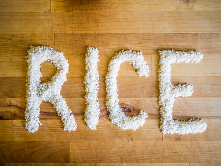 Rice word made of rice on wooden boardの写真素材