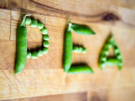 Word PEA created with peas on a wooden board with shallow depth of fieldの写真素材