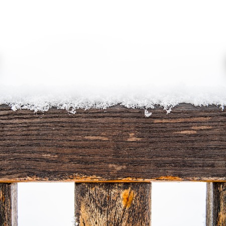 Detail of weathered painted wooden bench covered in snow, top of timber, plank or board with rungs or spokes, white copyspace on the top, winter time illustration or backgroundの写真素材
