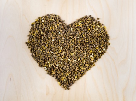 Heart shaped from raw dry brown lentils in cup, top view, center composition, food preparation, copy space, healthy lifestyle, eating legumesの写真素材
