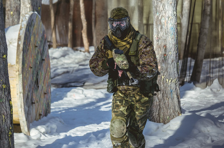 A man with a paintball marker is played on the fieldの写真素材