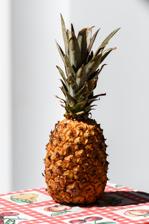 Pineapple on tablecloth and lightly grayish white background blurredの写真素材